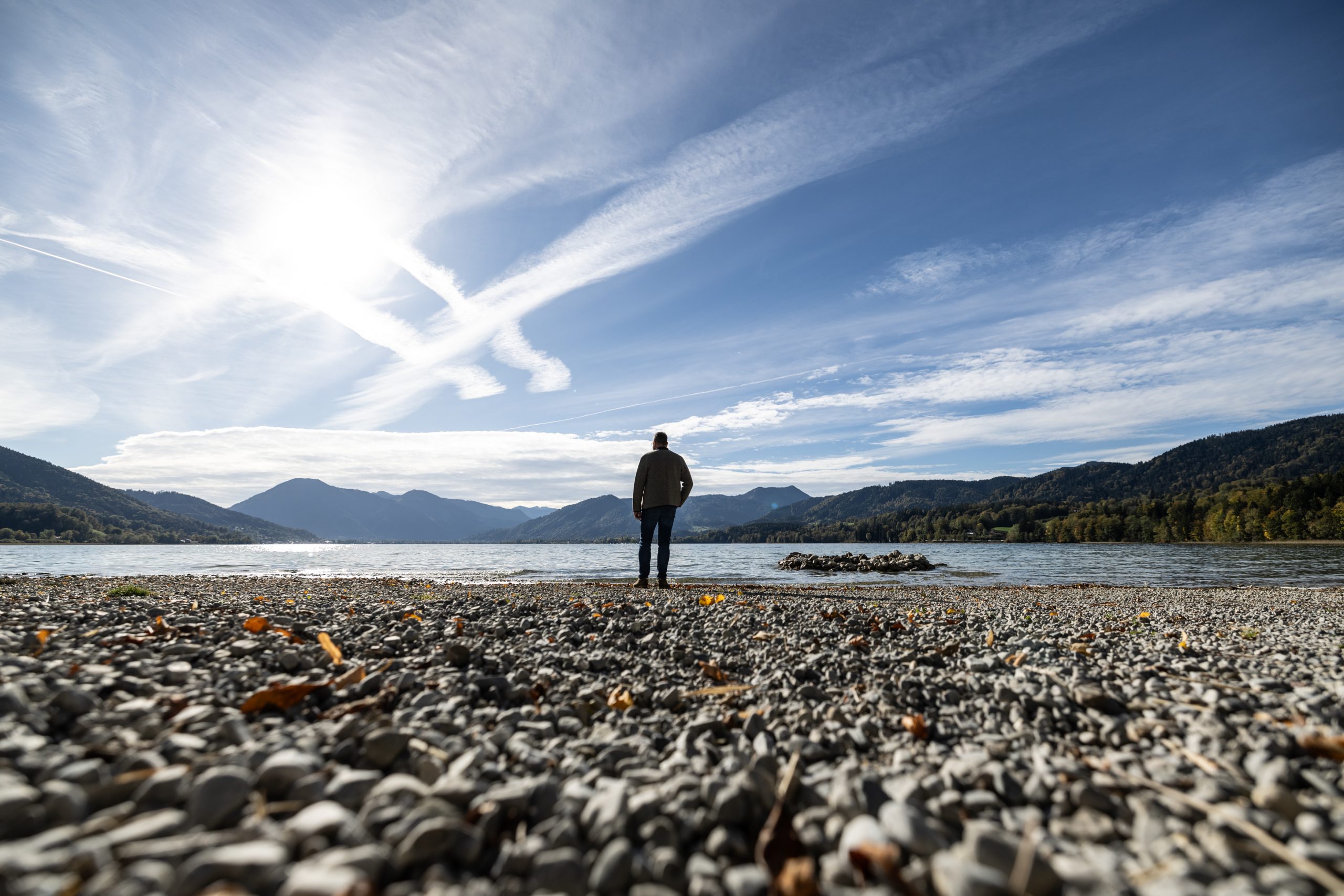 Markus Kasperbauer steht an einem See mit Kieselsteinen